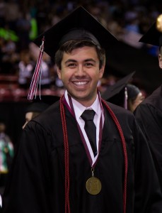 Graduate student in regalia, demonstrating the tassel on the left hand side. 