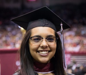 Undergraduate student in regalia, demonstrating the tassel on the right hand side. 